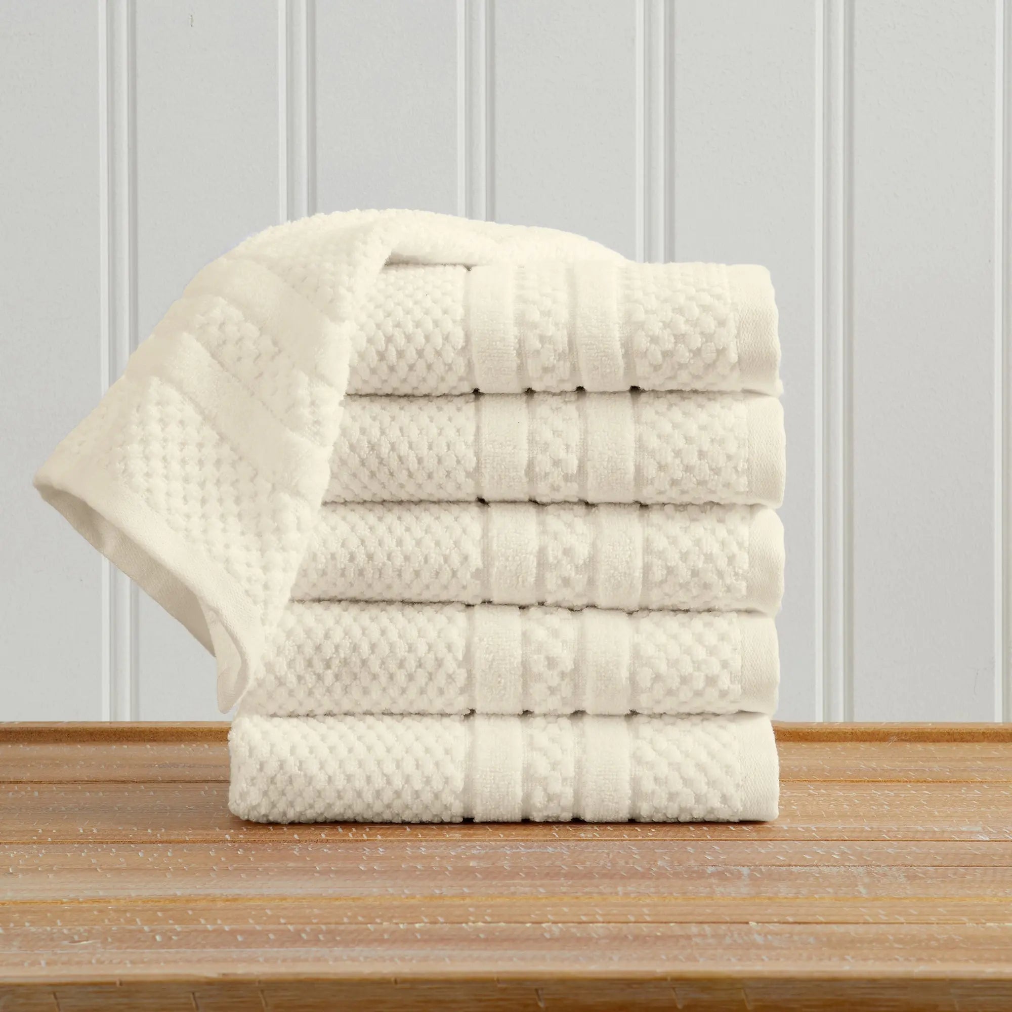 Bath towel set in white 100% cotton with a checkered jacquard pattern, neatly folded stack for display