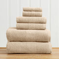 Great Bay Home Marbella Collection 5-piece bath towel set in beige, 100% cotton, stacked on a wood floor