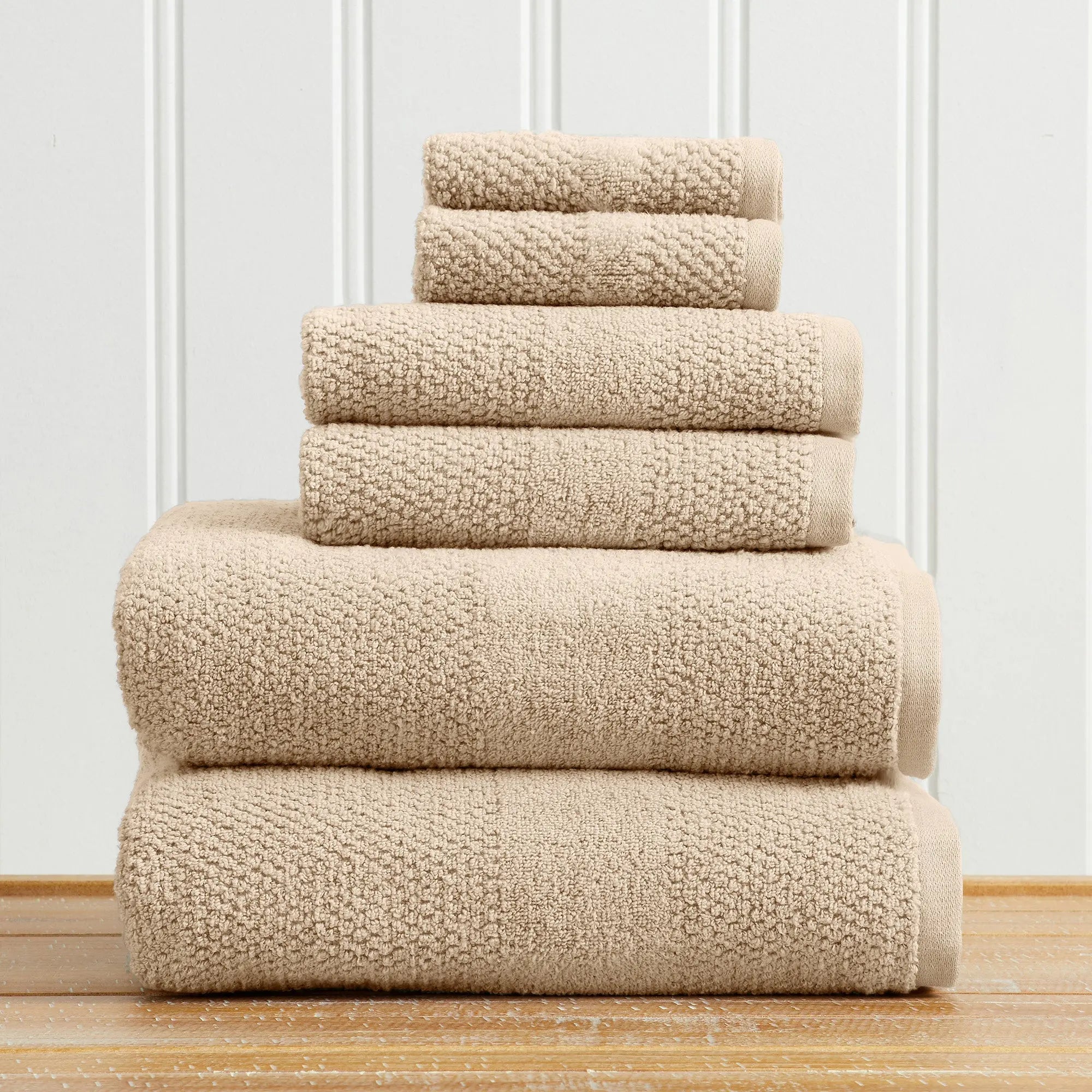 Great Bay Home Marbella Collection 5-piece bath towel set in beige, 100% cotton, stacked on a wood floor