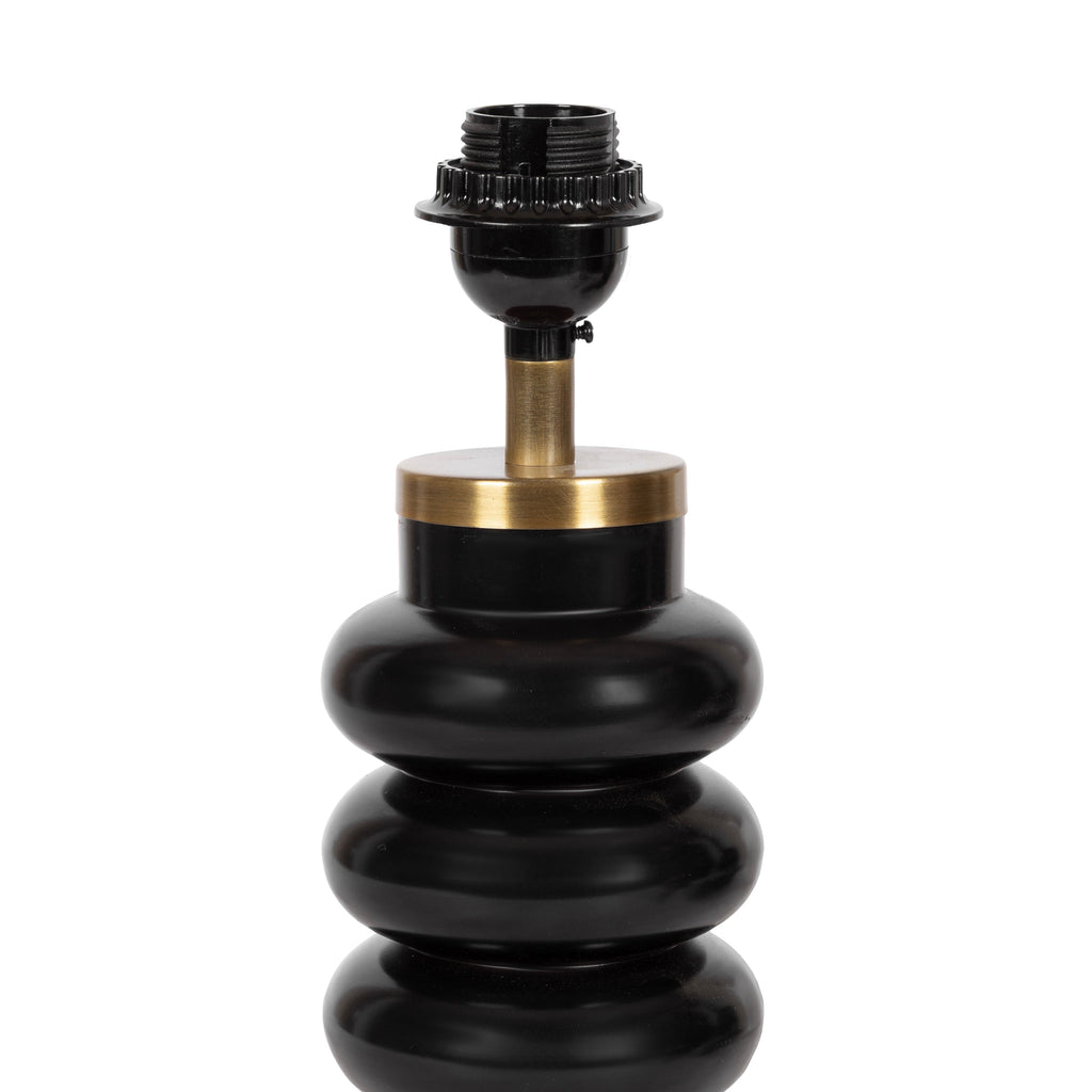 Black stacked orb lamp with brass base detail, adding contrast and architectural shape to a light interior.