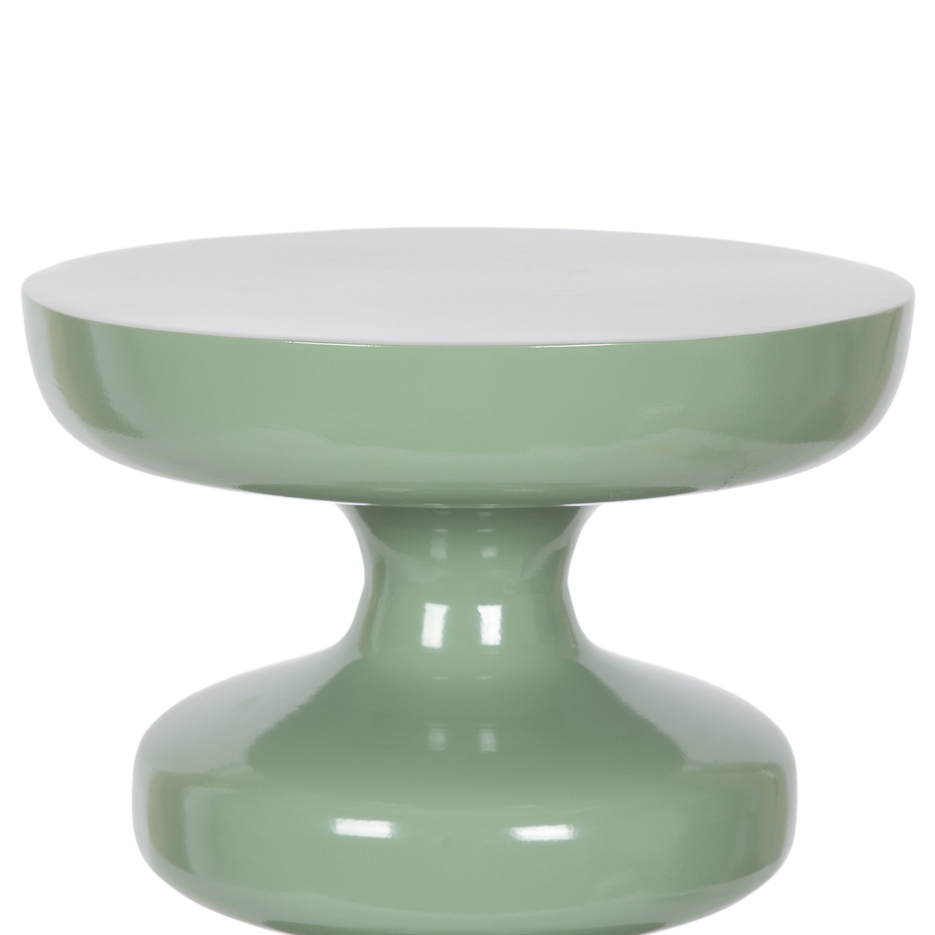 Sculptural sage green end table with a glossy finish, placed beside neutral seating and ocean‑inspired decor.