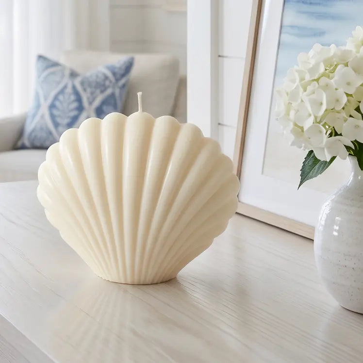 seashell shaped soy candle styled on coastal coffee table