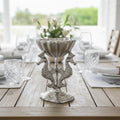 Decorative seahorse stand with a bowl on a wooden table.