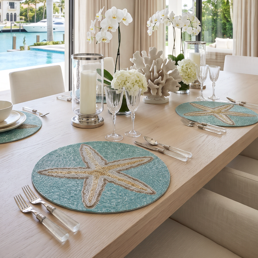Shell motif beaded placemat softening a modern coastal table with organic shapes and sparkle.