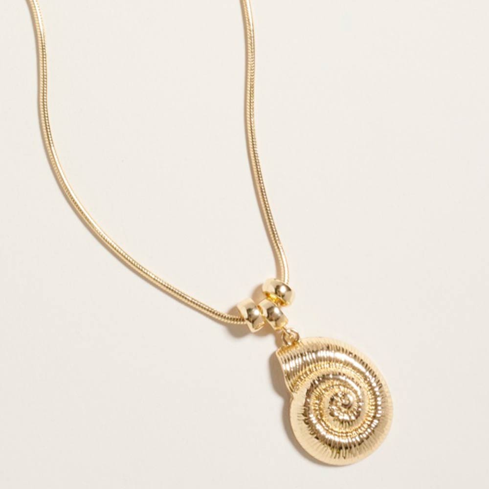 Simple gold seashell charm necklace shown as beach inspired everyday jewelry