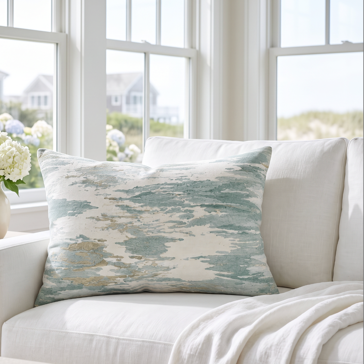 Soft aqua and sand watercolor pattern lumbar pillow that adds a calm coastal feel to a light sofa.