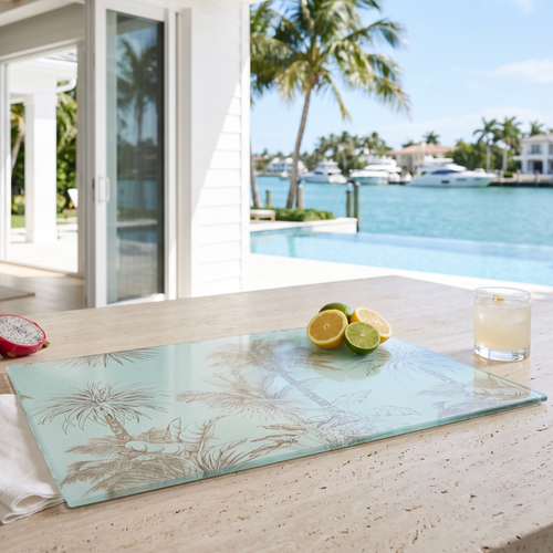 Tropical palm motif cutting board adding a relaxed island vibe to the cooking and serving area.