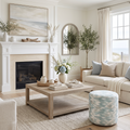 Round upholstered pouf with a soft blue and white watercolor-style abstract pattern.