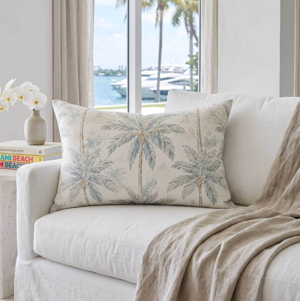 Coastal palm print pillow that ties together beachy artwork, driftwood, and neutral upholstery.