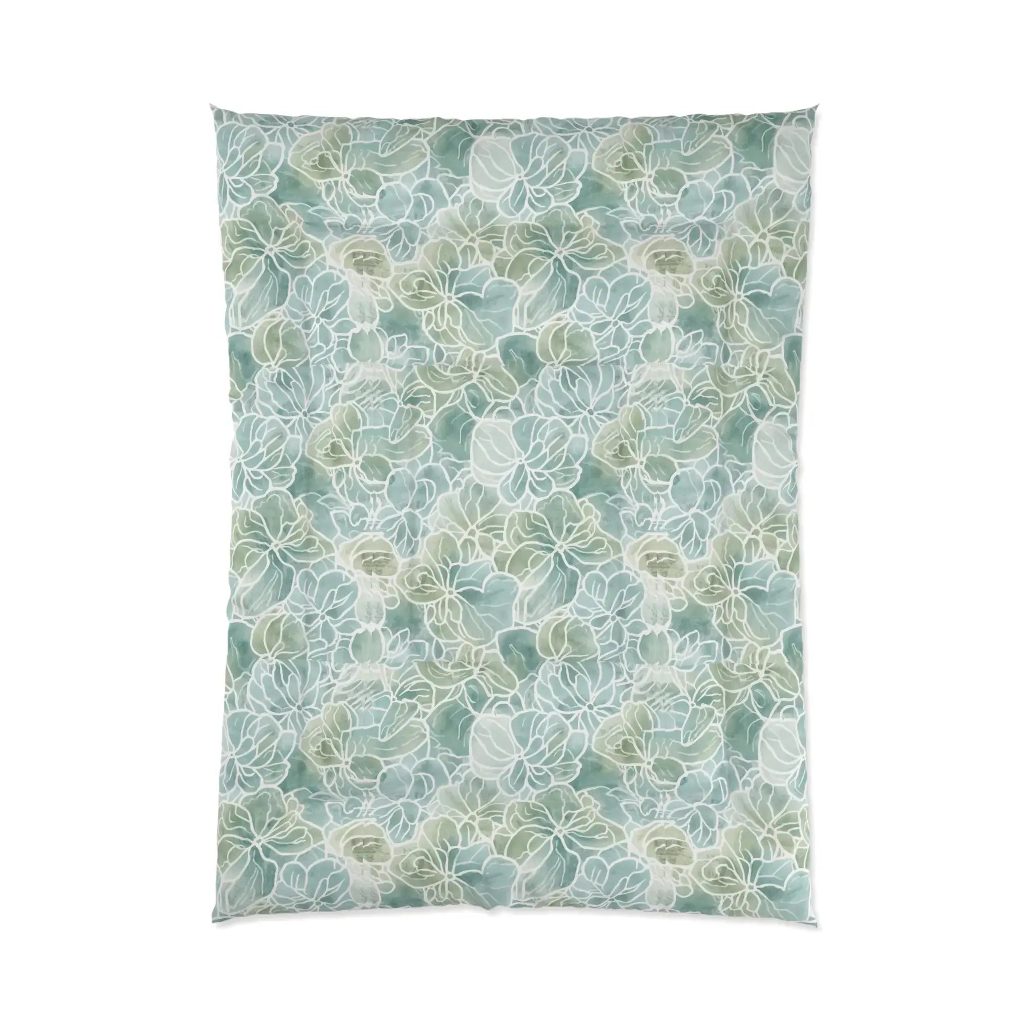 Light blue/green floral comforter set layered with white pillows in a relaxed coastal bedroom