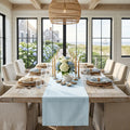 Solid light blue table runner on a light wood table for simple beach house decor