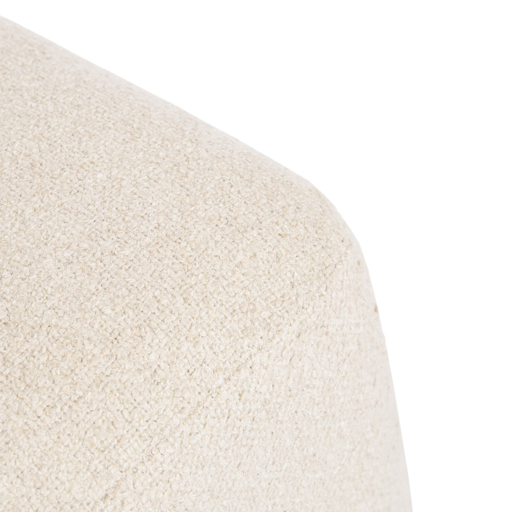 Square cream boucle ottoman with a wood base in a living room