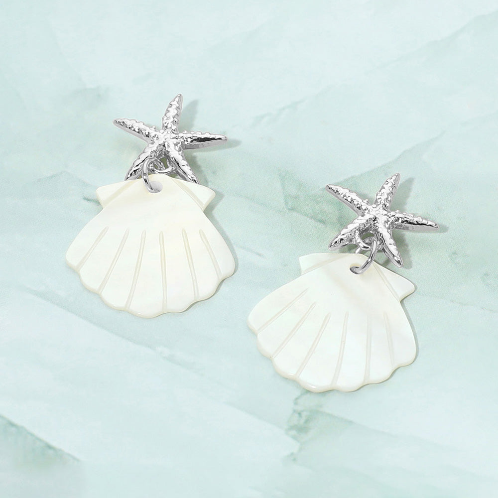Coastal starfish accent mother of pearl shell dangle earrings shown as beach inspired jewelry.