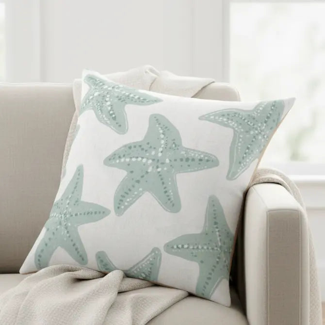 Starfish Coastal Throw Pillow with teal starfish pattern on white fabric, a coastal accent for neutral interiors.
