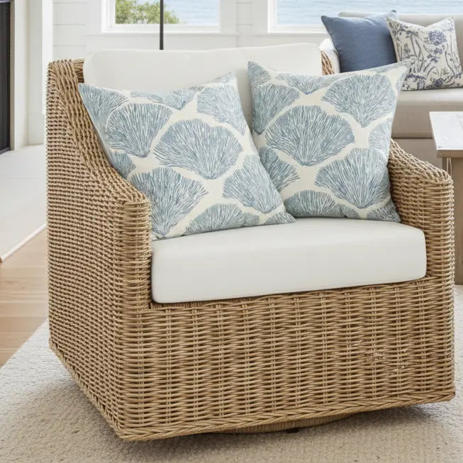 Bar Harbor Coral Throw Pillow with coastal blue coral pattern on a woven wicker chair