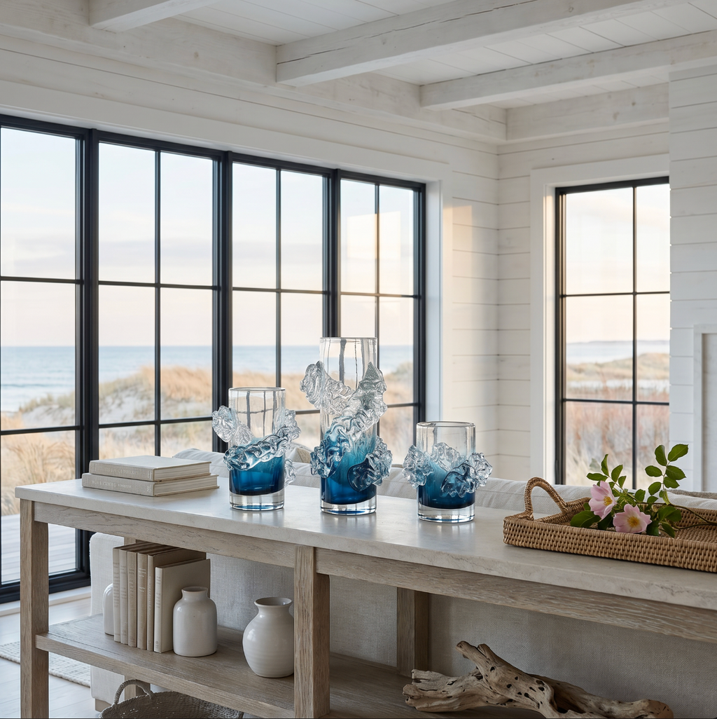 Handblown wavy blue and clear glass vase displayed on a console table for coastal home decor.