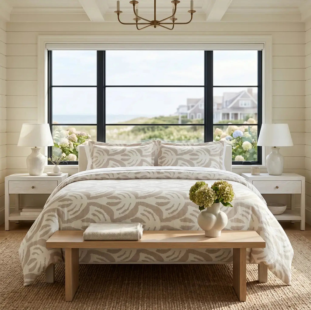 Tan pattern comforter on a bed with white sheets in a neutral coastal bedroom