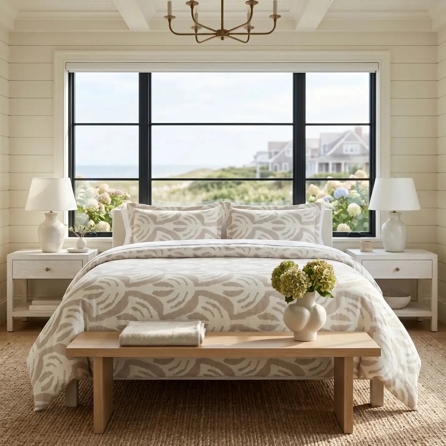 Tan pattern comforter on a bed with white sheets in a neutral coastal bedroom