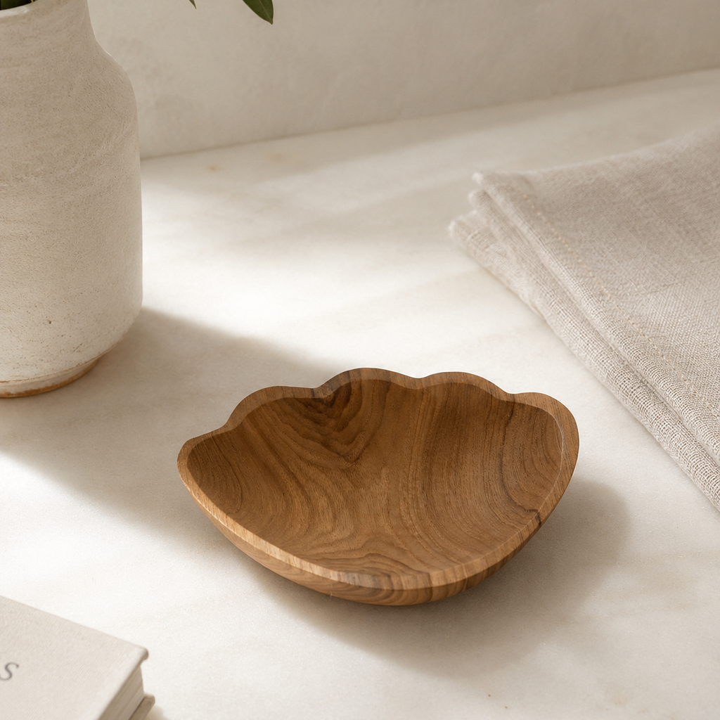 Handcrafted teak shell catchall with a natural wood finish for coastal home decor.