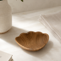 Handcrafted teak shell catchall with a natural wood finish for coastal home decor.