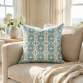 Teal coastal ikat throw pillow on a couch in a beach house style living room