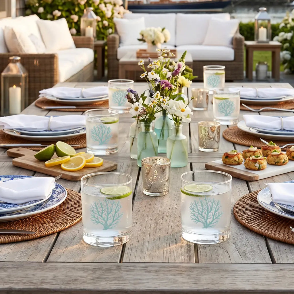 Teal coral cocktail glass on an outdoor table in a beach-inspired patio.