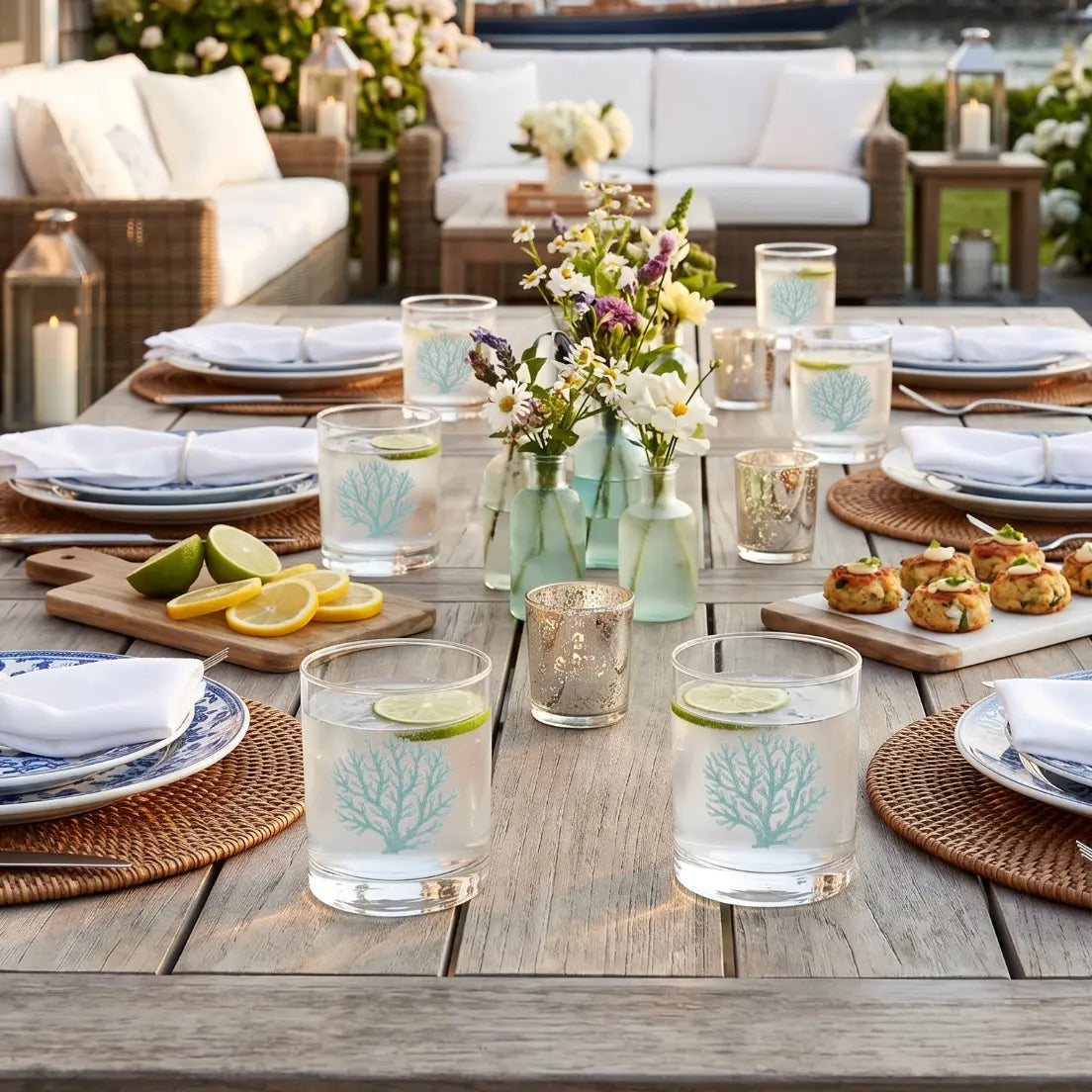 Teal coral cocktail glass on an outdoor table in a beach-inspired patio.