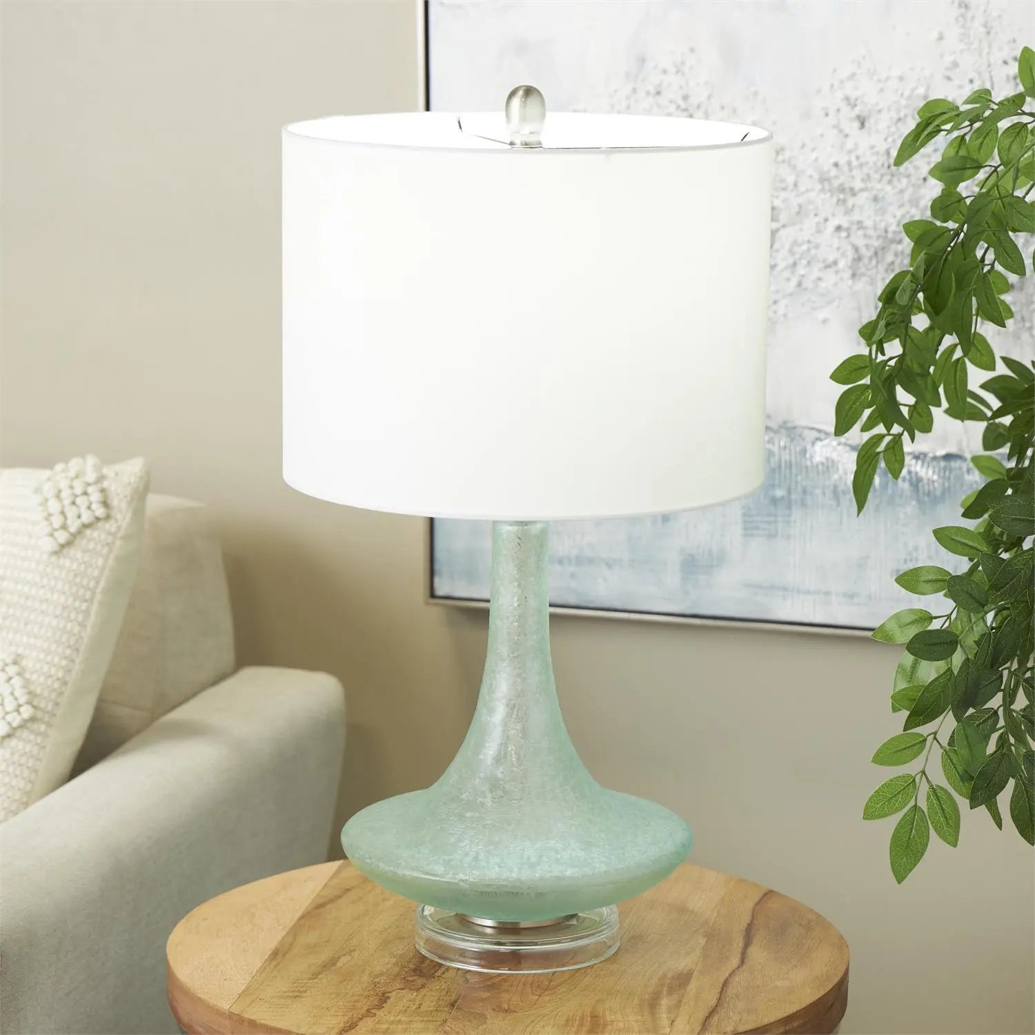 Seaglass Glow Lamp with teal seaglass base and white fabric shade on a round wood table.