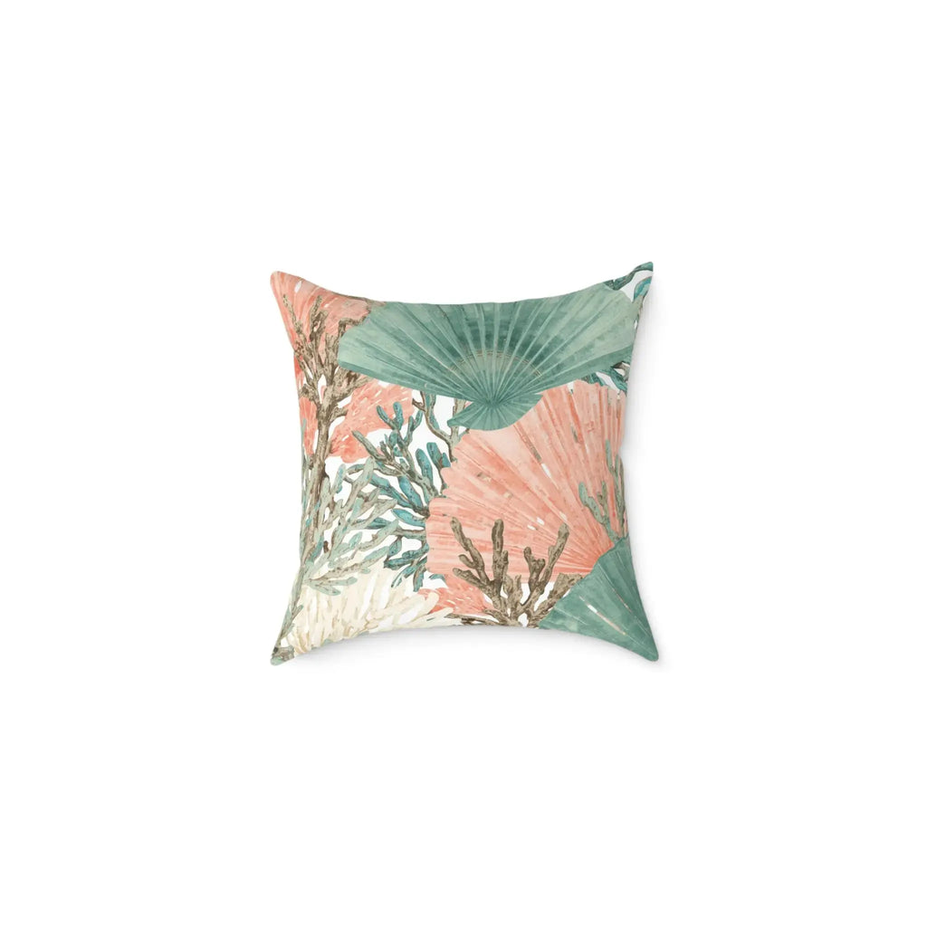 Teal and salmon coral and shell accent pillow on an armchair in a seaside cottage living room