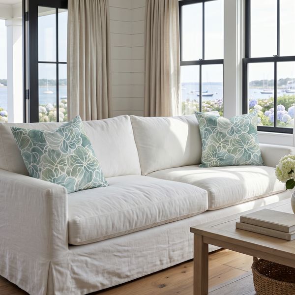 Tidewater throw pillow with misty seafoam watercolor botanicals styled on a neutral coastal sofa