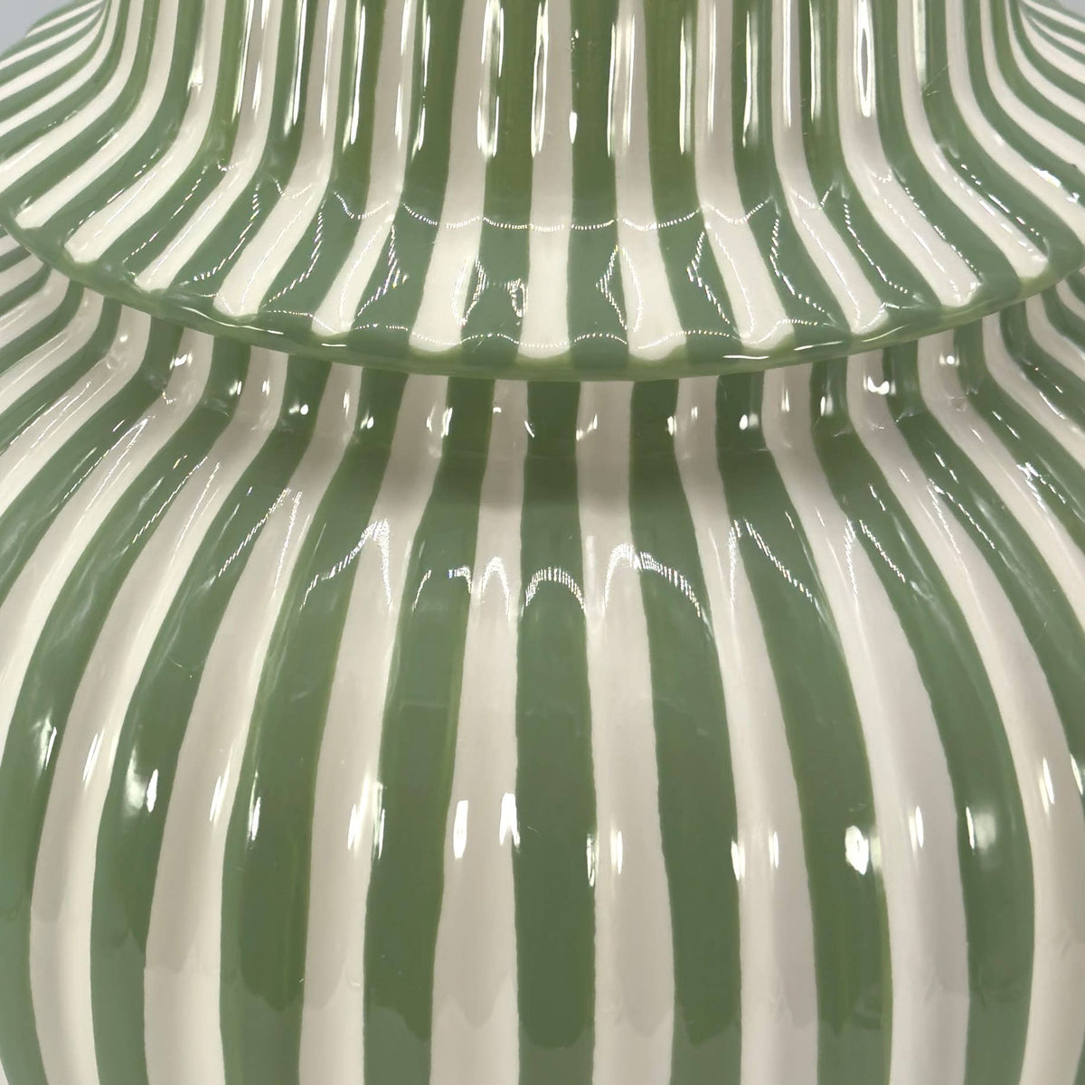 Traditional green and white striped ceramic vase with a decorative lid and glossy glaze.