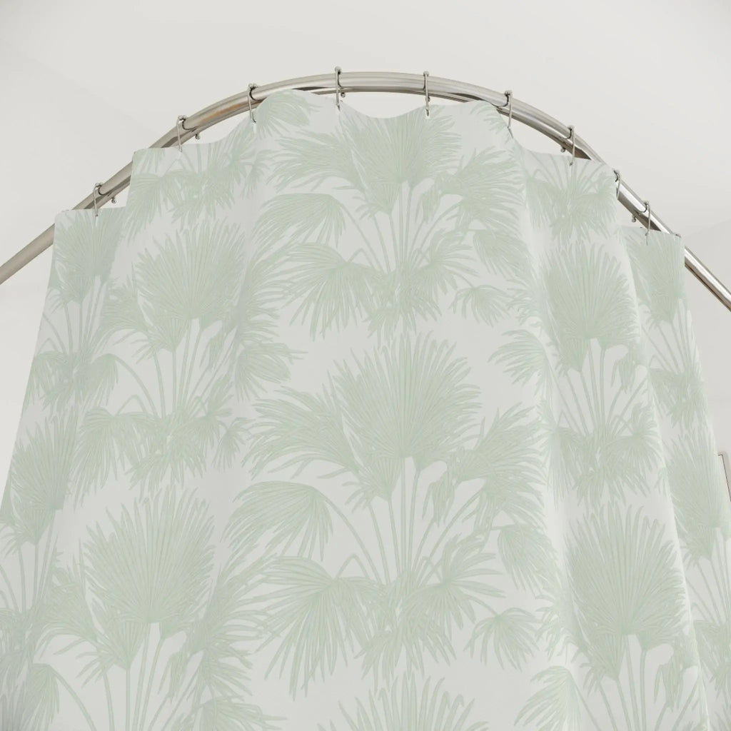 Coastal palm print polyester shower curtain in soft sage green.