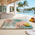 Tropical coral pattern glass cutting board displayed in a modern coastal kitchen with pool and ocean views.