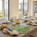 Set of Monstera Leaf Iraca placemats arranged for a tropical coastal table setting