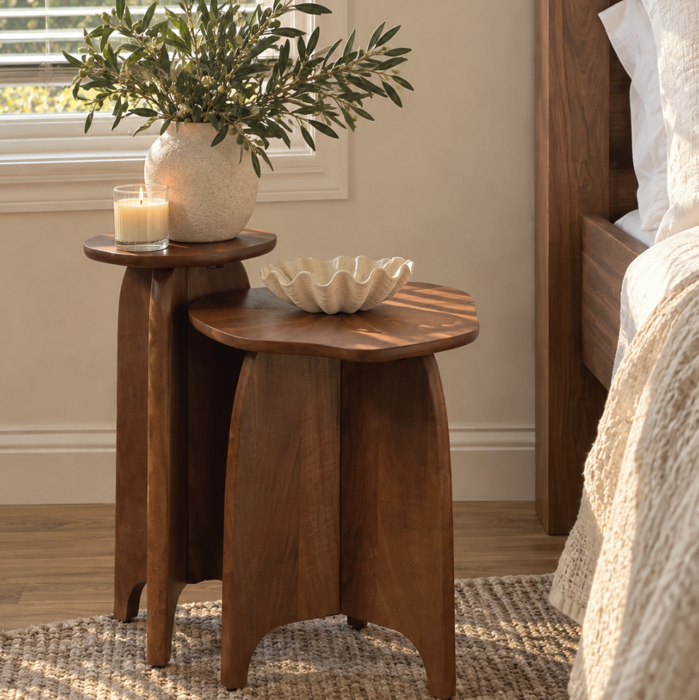 Two-piece wooden nesting table set featuring a smaller drink table and larger sculptural side table.