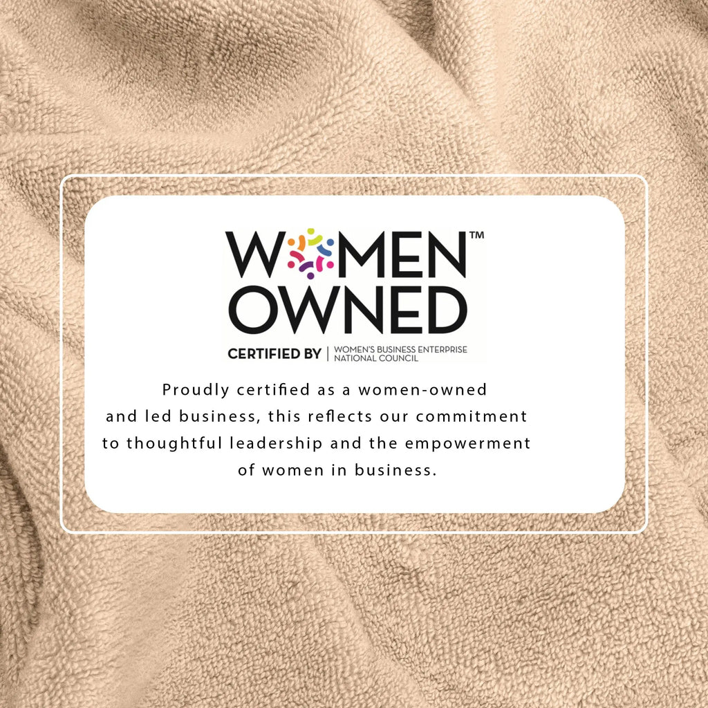 Beige bath towel with Women-Owned certification label