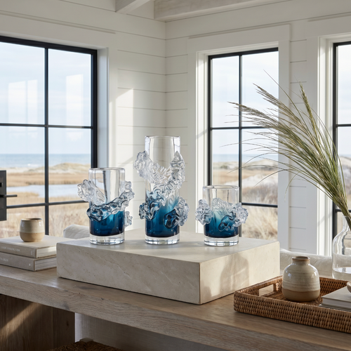 Tall wavy blue and clear glass vase with flowers styled in a beach house living room