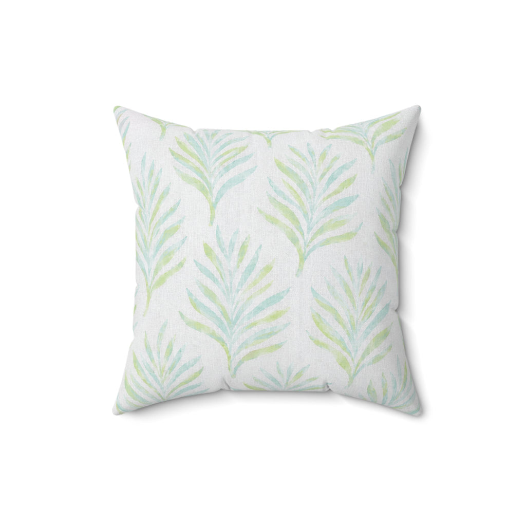 White decorative pillow with blue and green palm leaf patterns