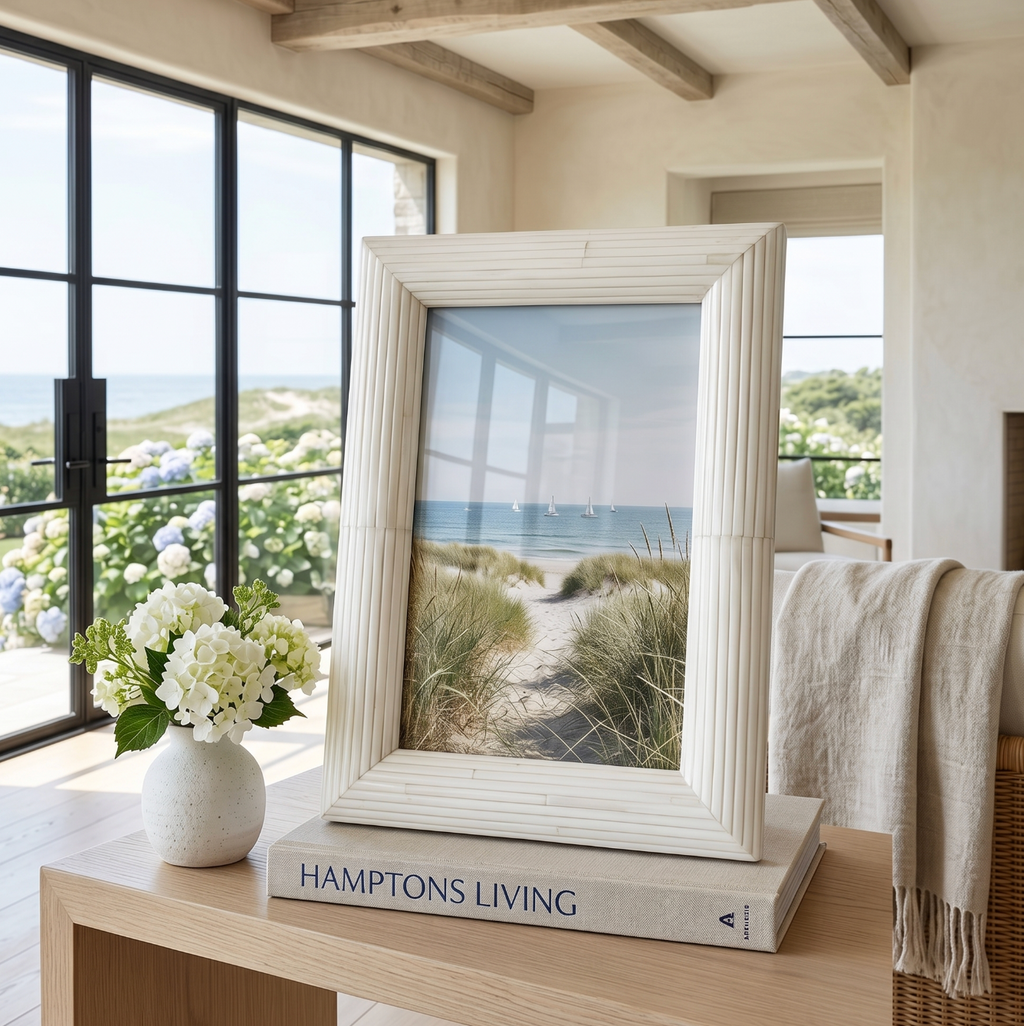 White bone inlay picture frame holding a 4x6 photo styled on a coastal console table