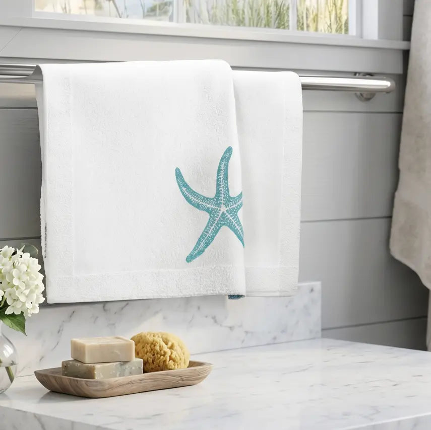 Coastal white starfish face towel hanging on a hook in a beach house bathroom.