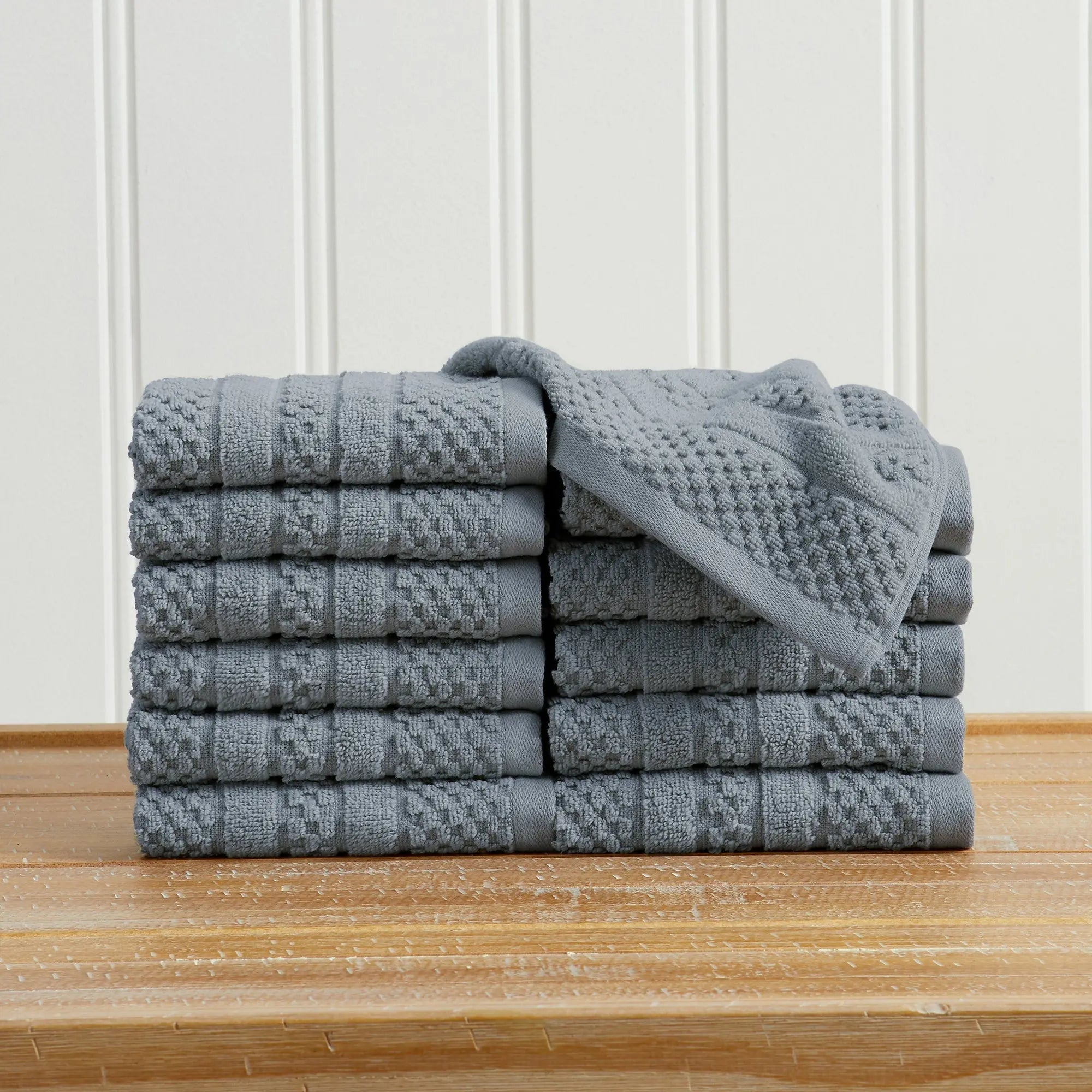 100% cotton checkered jacquard bath towel set, Giuliana Collection, gray, stacked on a wooden surface.