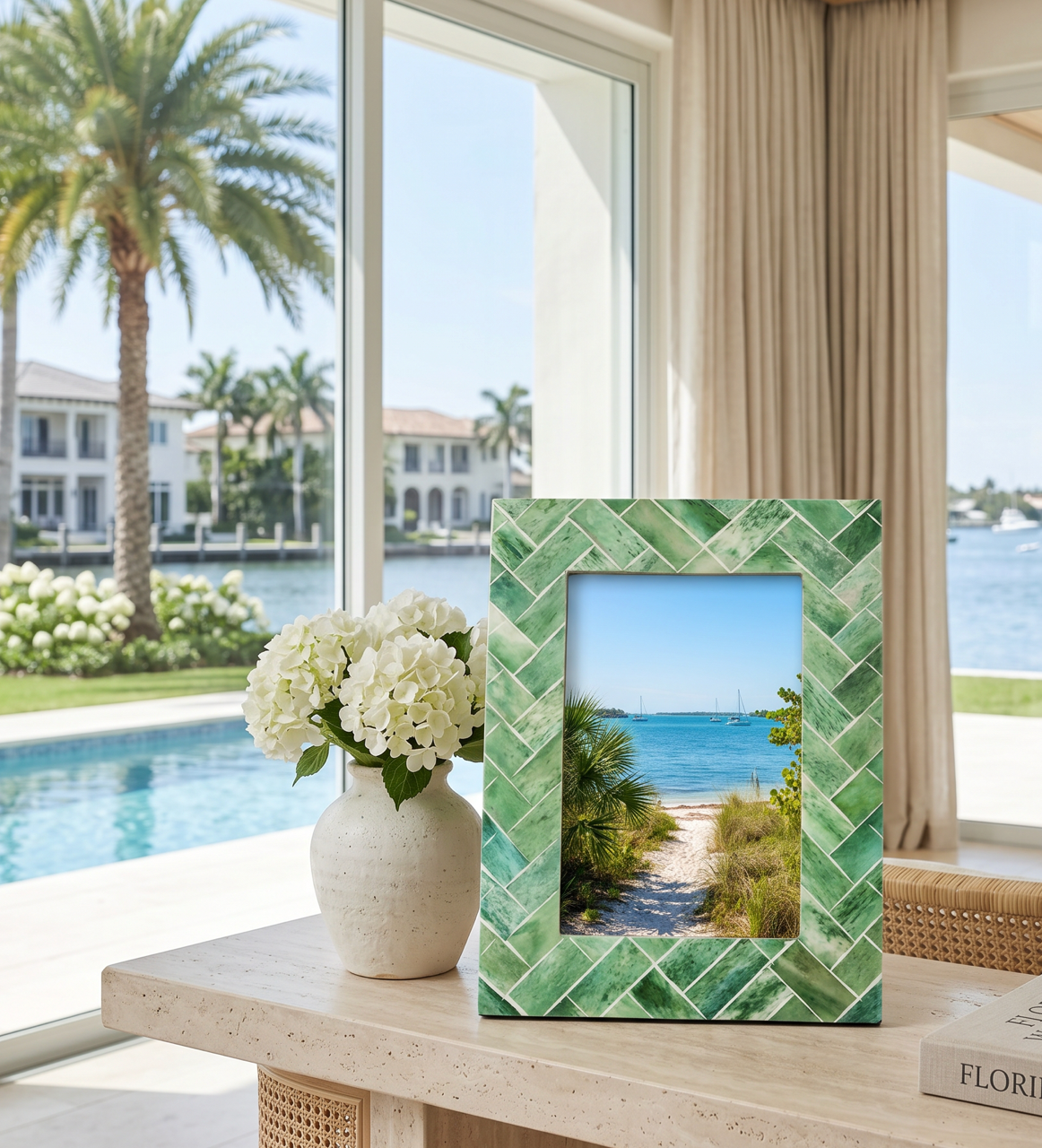 Textured green tropical picture frame with palm leaf design standing on a shelf with coastal decor