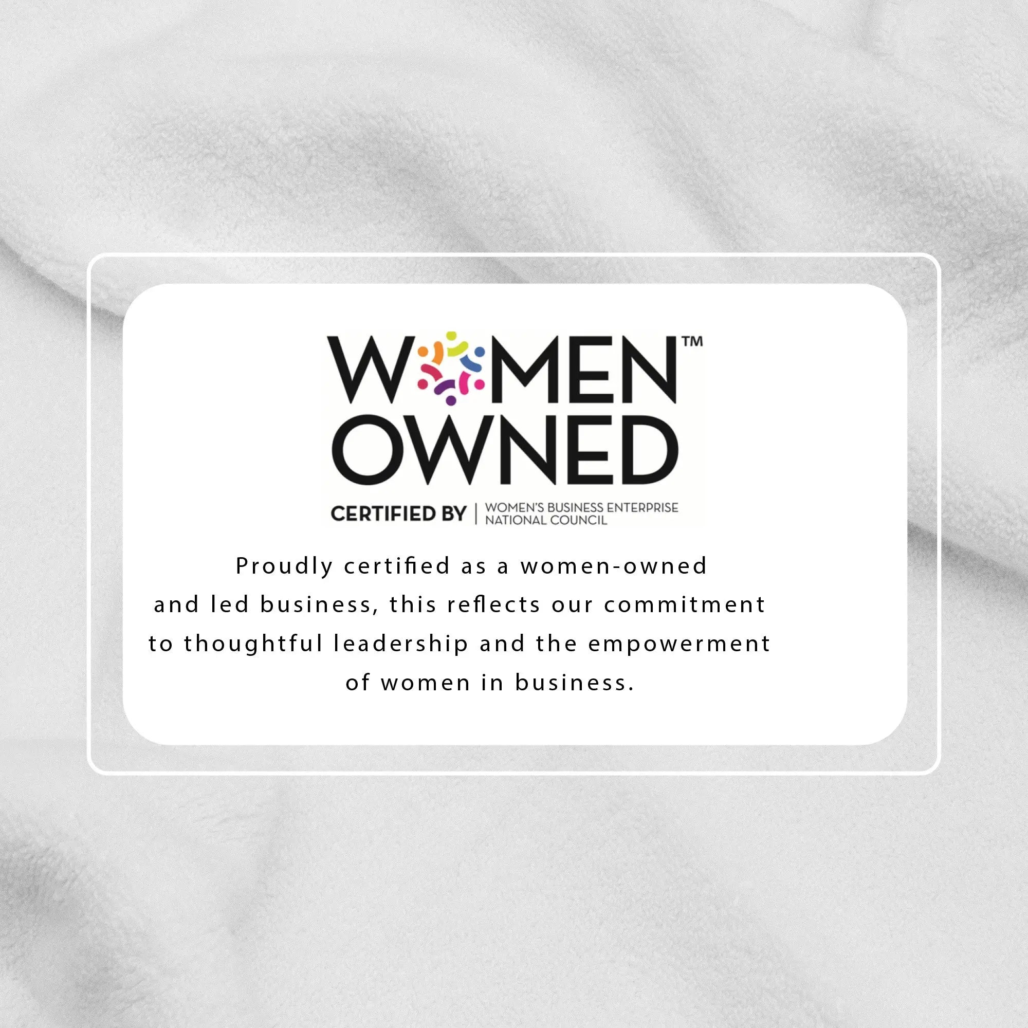 Bath towel set background with soft gray towel fabric and Women-Owned certification badge overlay